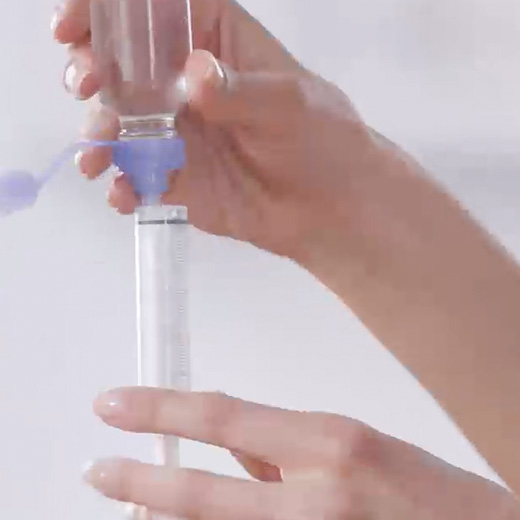 Syringe inserted in RAVICTI bottle.
